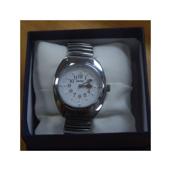 Braille quartz watch displayed on watch pillow in product box.