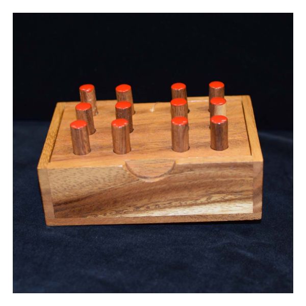 Wood base with two Braille cells containing red wood pegs.